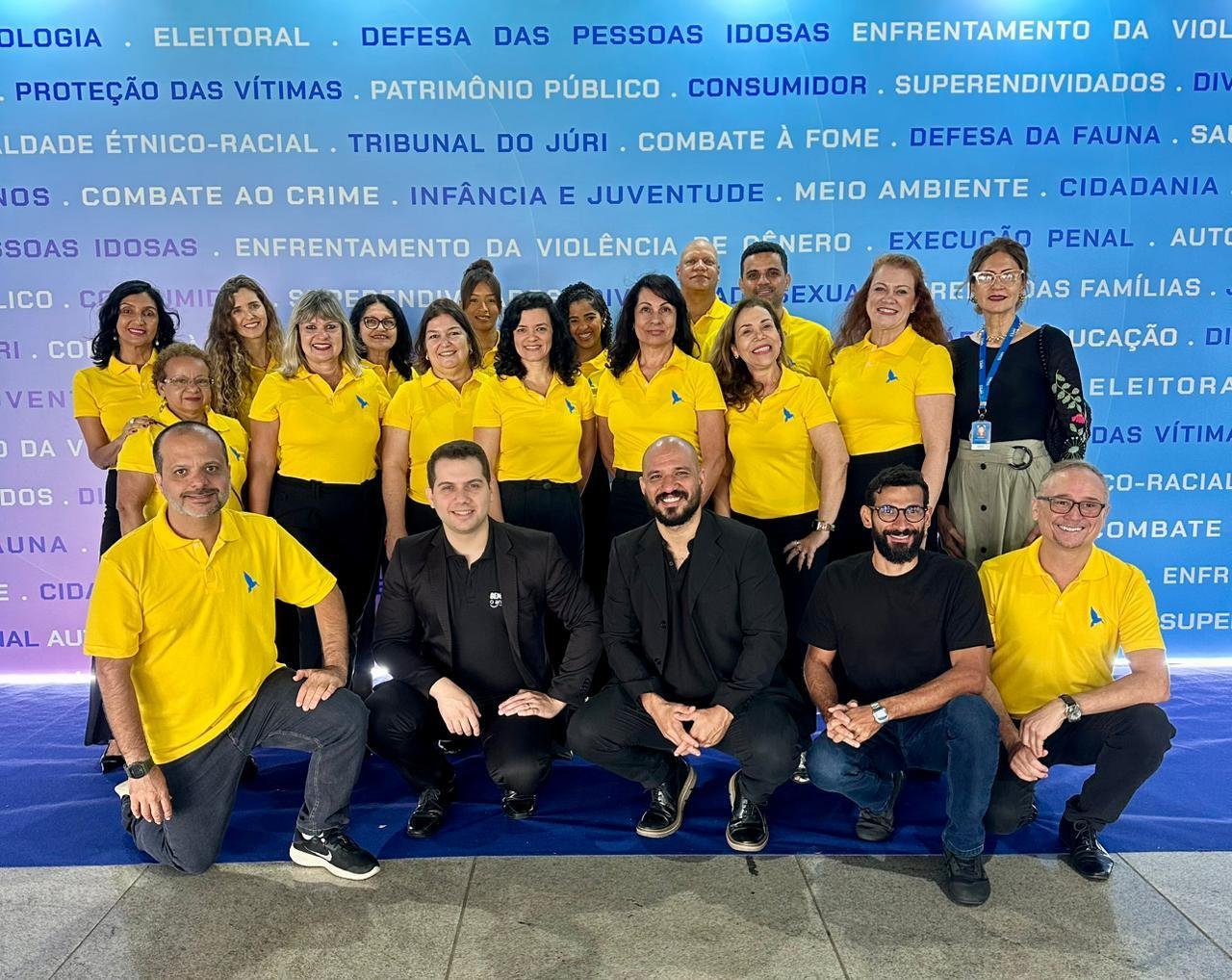 Equipe reunida usando polos amarelas personalizadas em evento